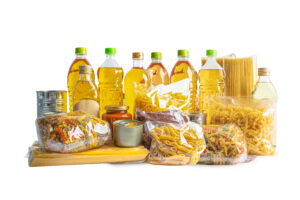 Foodstuff for donation isolated on white background, storage and delivery. Various food, pasta, cooking oil and canned food.